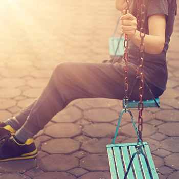 Lonely woman missing her boyfriend while swinging in the park villa in the morning